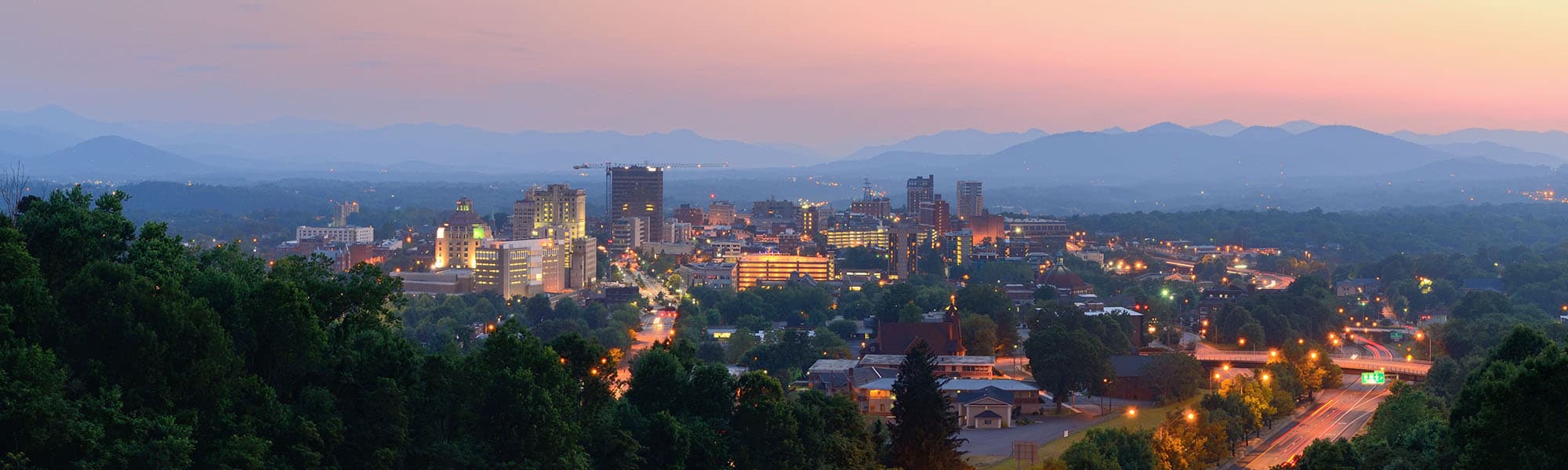 HVAC technician servicing residential air conditioning in Asheville, NC
